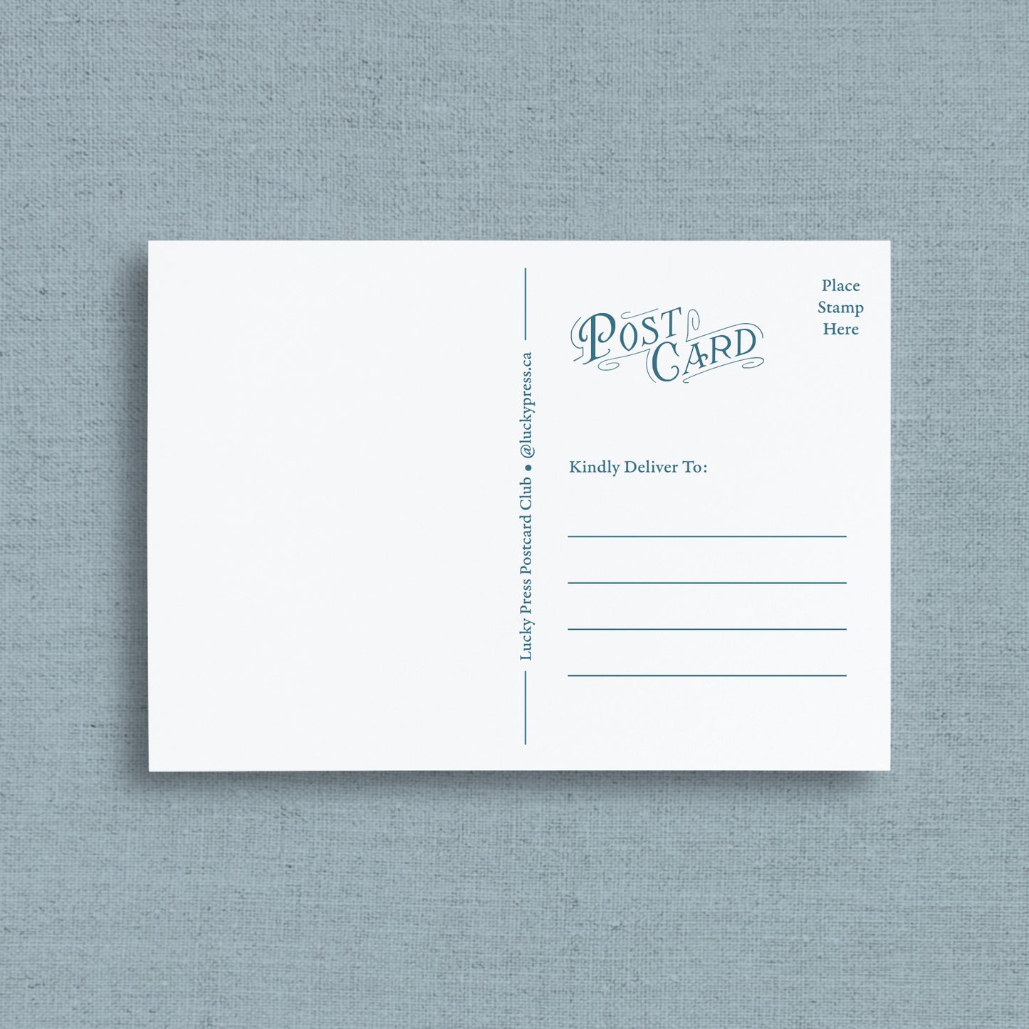 Reverse side of post card with blue printed text and lines, displayed flat against a textured light blue-gray background. The postcard features the words 'Post Card' in blue script, along with fields for destination and stamp placement.