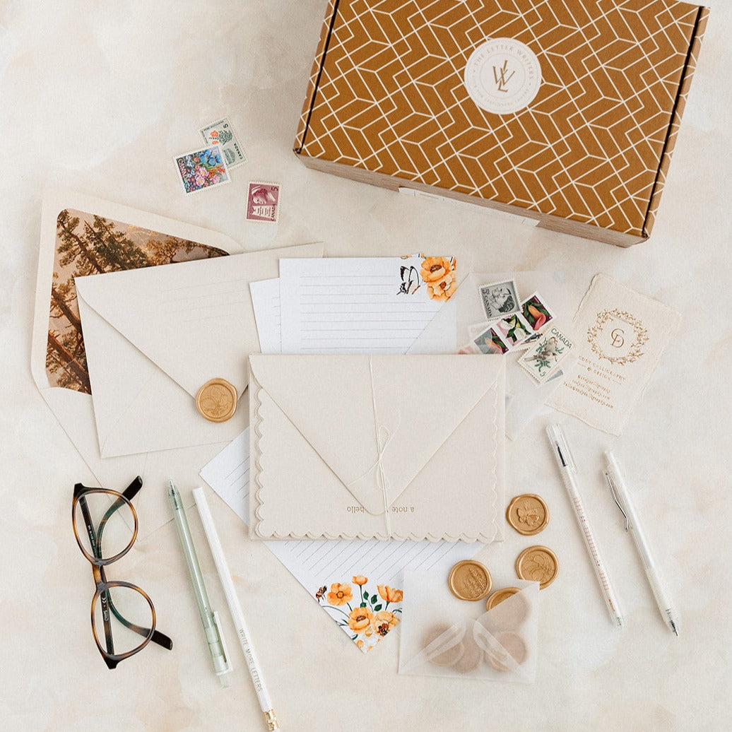 arrangement of fine stationery including note cards, envelopes, writiing tools, wax seals, and more.